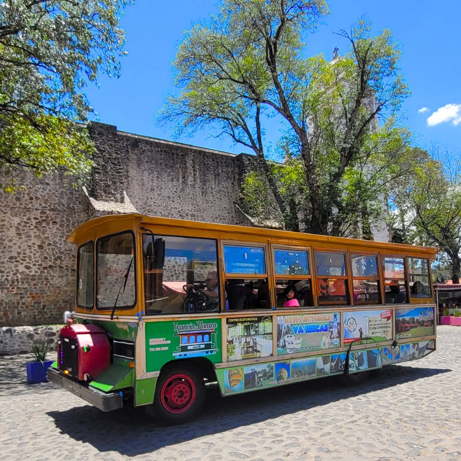 Tranvía turístico de Huasca frente a una construcción histórica